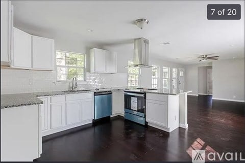 A kitchen with white cabinets and a blue dishwasher.