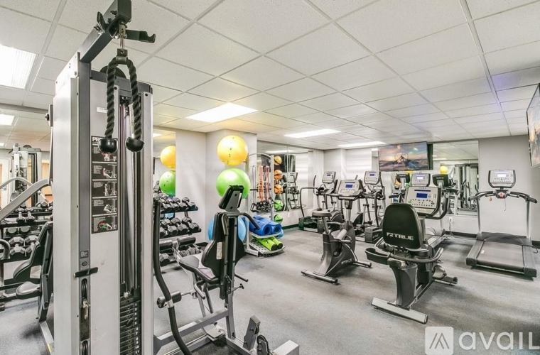 A gym with a variety of exercise equipment including treadmills, stationary bikes, and weight machines.
