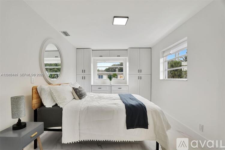 A bedroom with a large bed and a mirror on the wall.