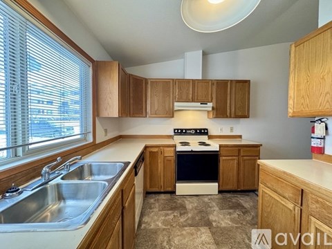 A kitchen with wooden cabinets and a checkered floor.