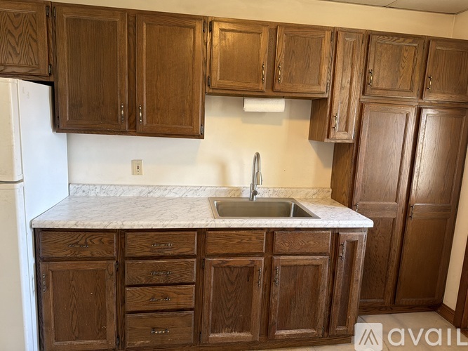 A kitchen with wooden cabinets and a marble countertop.