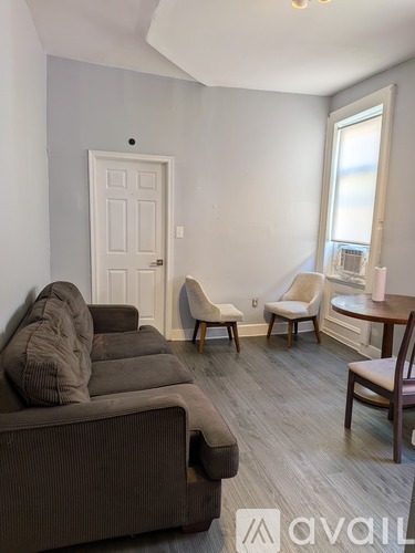 A living room with a brown couch and a white door.