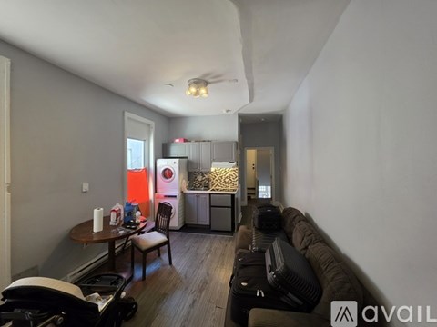 A living room with a couch, chair, and a table with some items on it.