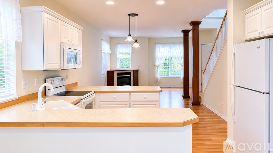 A kitchen with white cabinets and a wooden island.