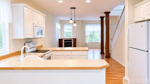 A kitchen with white cabinets and a wooden island.