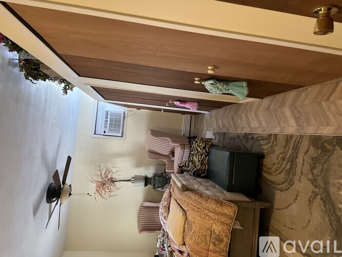A room with a ceiling fan and a couch.