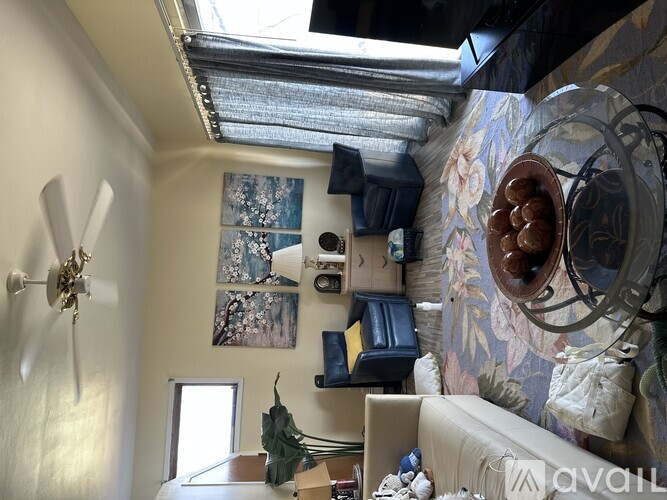 A room with a ceiling fan and a wall with a painting on it.