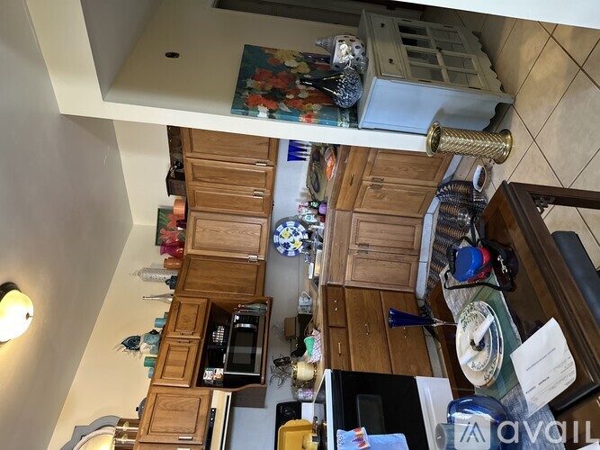 A kitchen with wooden cabinets and a microwave.