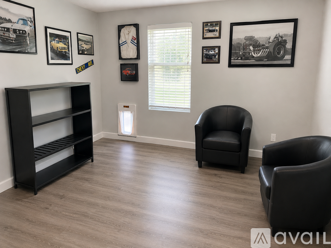 A living room with a black chair and a black shelf.
