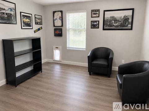 A living room with a black chair and a black shelf.