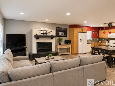 A living room with a grey couch and a fireplace.