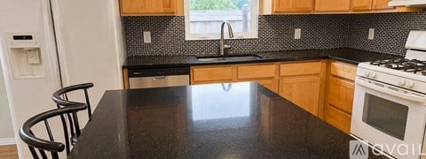A kitchen with a black countertop and wooden cabinets.