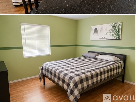 A bedroom with a bed, a window with blinds, and a painting on the wall.