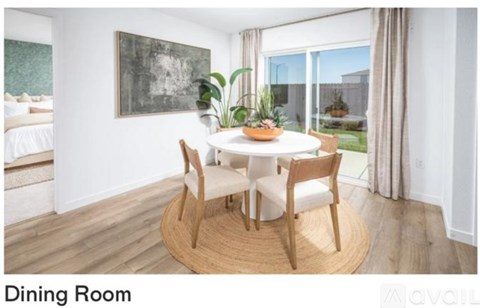 A dining room with a white table and chairs.
