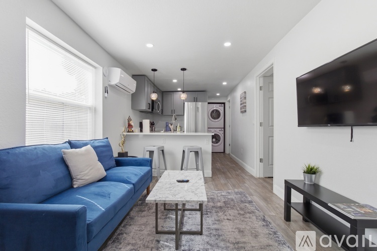 A living room with a blue couch and a white coffee table.