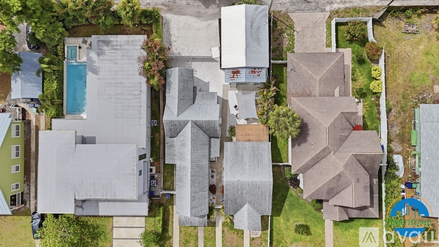 A bird's eye view of a residential area with houses and a swimming pool.