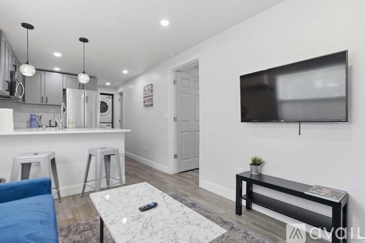 A modern kitchen with a blue chair and a black countertop.