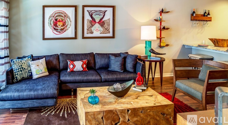 A living room with a couch, a table, and two framed pictures on the wall.