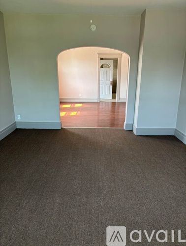A hallway with a carpeted floor and a white door at the end.