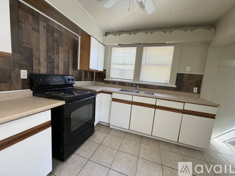 A kitchen with a black oven and white cabinets.