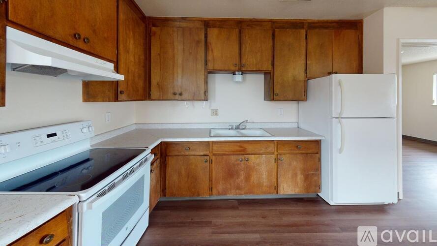 A kitchen with wooden cabinets and white appliances.