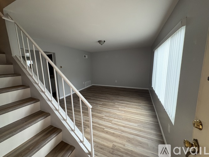 A white staircase with a landing and a window.