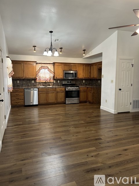 A kitchen with wooden cabinets and a stainless steel dishwasher.