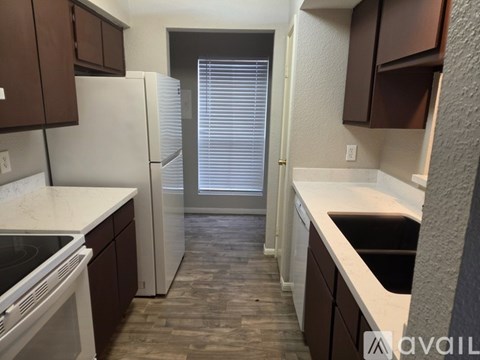A kitchen with brown cabinets and a white fridge.