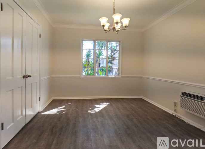 A room with a window and a chandelier.