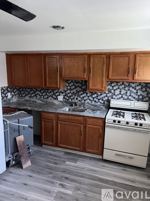 A kitchen with wooden cabinets and a white stove.