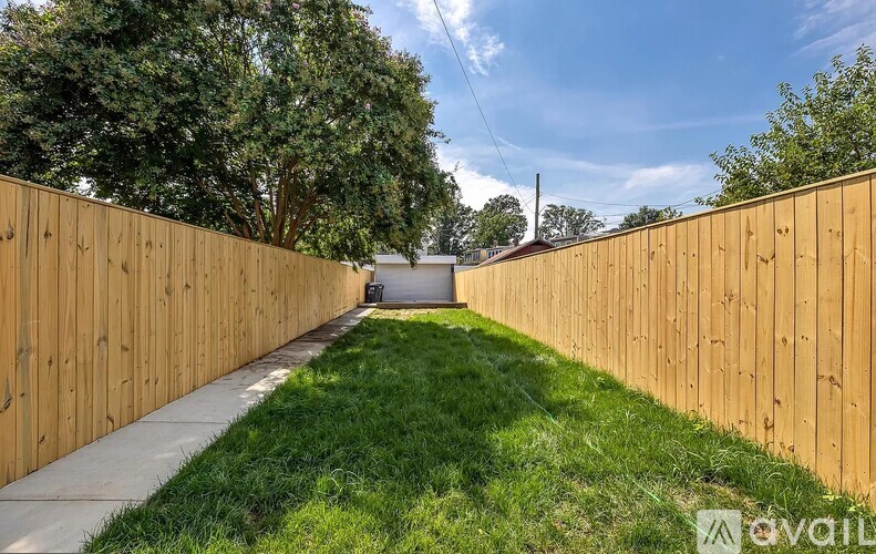 A wooden fence runs along a grassy path.