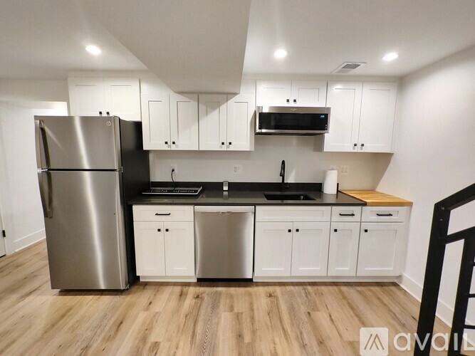 A kitchen with a refrigerator, microwave, and oven.