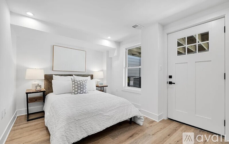 A bedroom with a large bed and a white door.