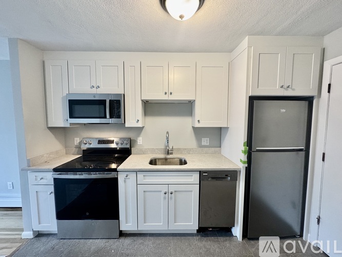 A kitchen with white cabinets and a black stove top.