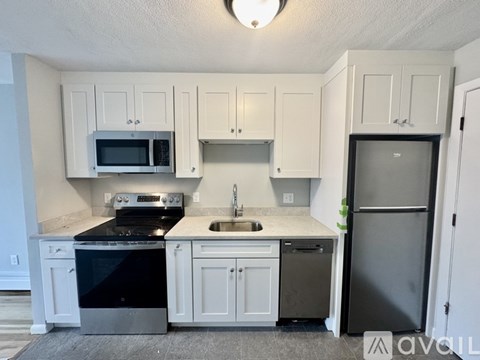 A kitchen with white cabinets and a black stove top.
