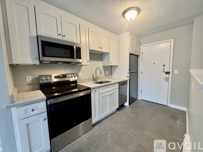 A kitchen with white cabinets and a black stove top oven.