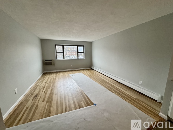 A room with wooden flooring and a window.
