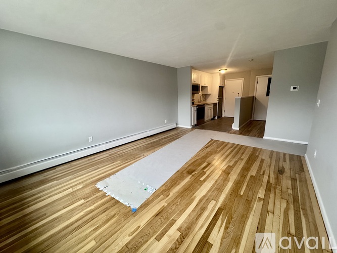 A room with wooden flooring and a white wall.