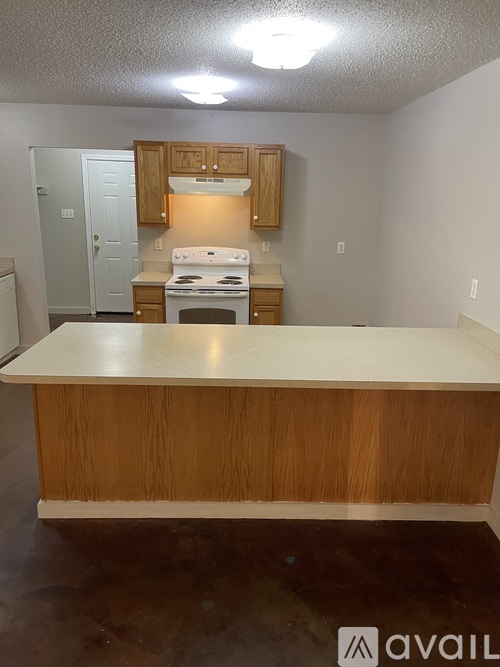 A kitchen with a white counter top and wooden cabinets.