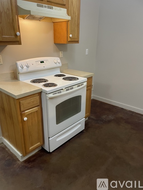A white stove and oven in a kitchen with wooden cabinets.