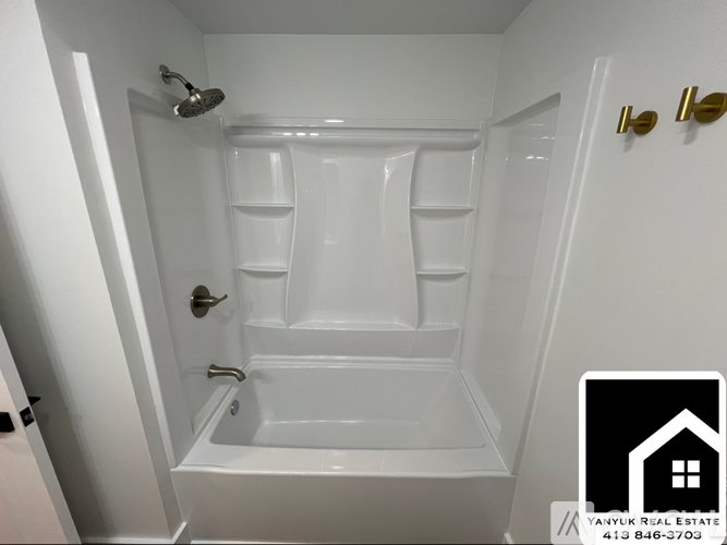 A white bathroom with a bathtub and a shower.