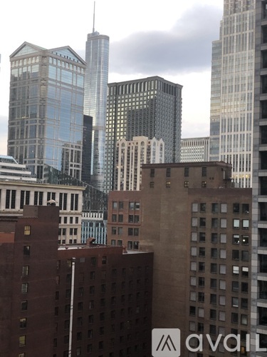 A cityscape with tall buildings and a cloudy sky.