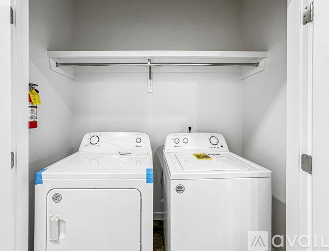 Two white washing machines in a small laundry room.