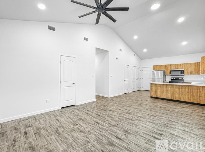 A spacious room with a ceiling fan and a wooden counter.