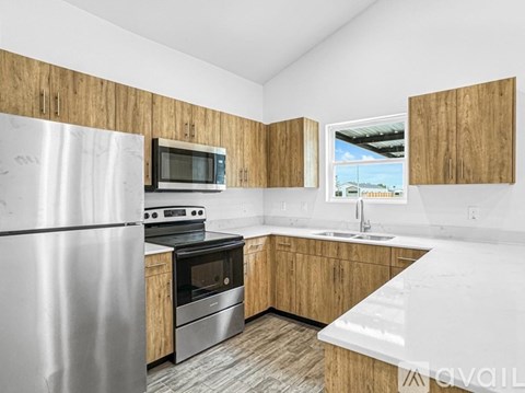 A kitchen with a refrigerator, oven, microwave, sink and cabinets.