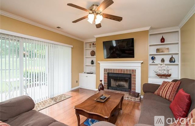 A living room with a fireplace and a television on the wall.