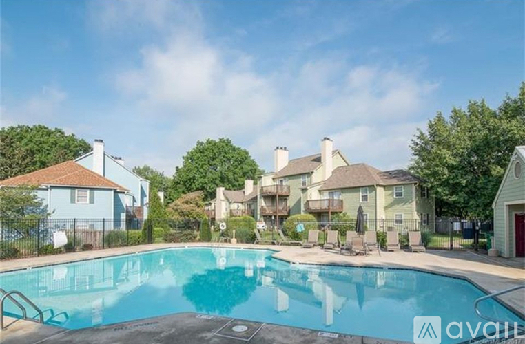 A pool surrounded by houses and trees.