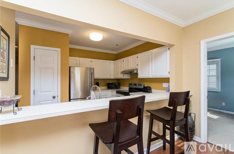 A kitchen with white cabinets and a white countertop.