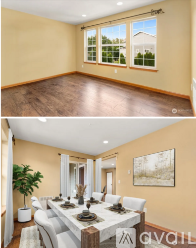 A dining room with a white table and chairs and a painting on the wall.