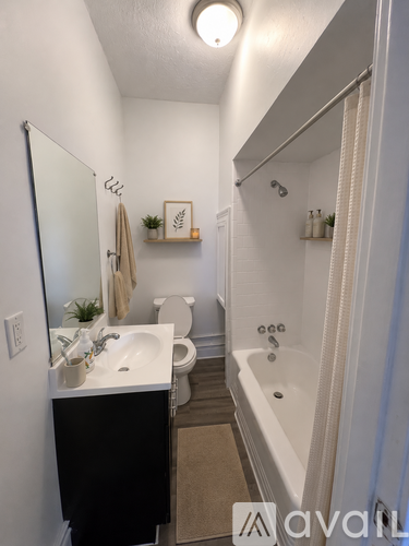 A bathroom with a white tub, sink, and toilet.